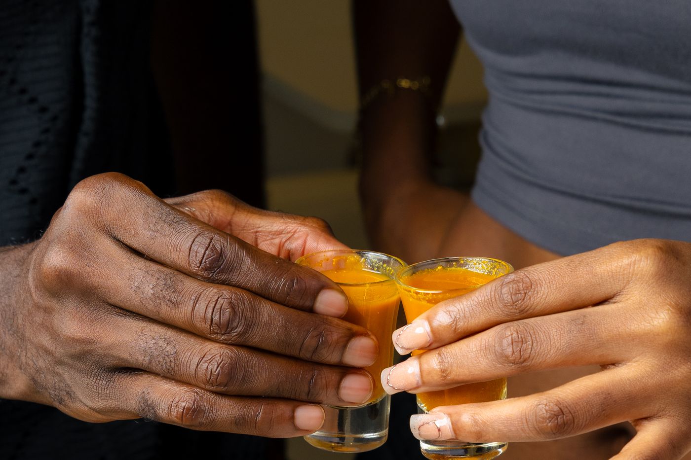 Two guests clinking turmeric wellness shots at the Wellnex counter