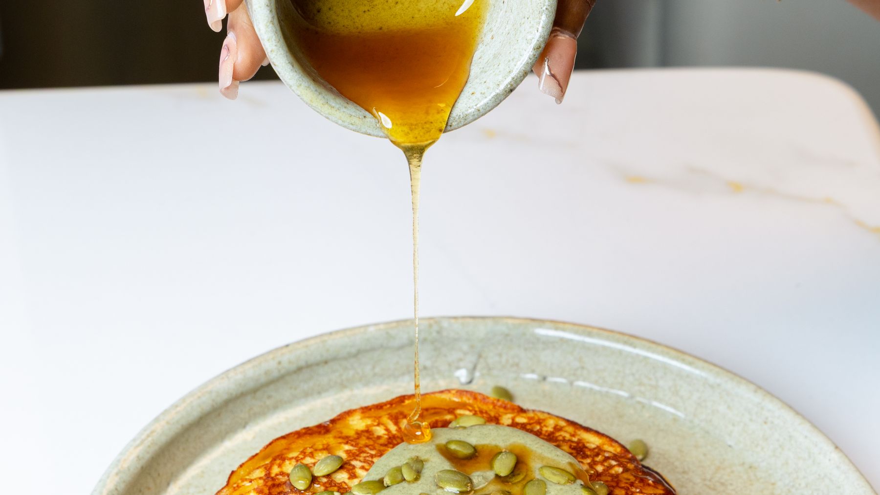 Maple pouring over Wellnex pancakes — every plan meal cooked fresh, twice a day