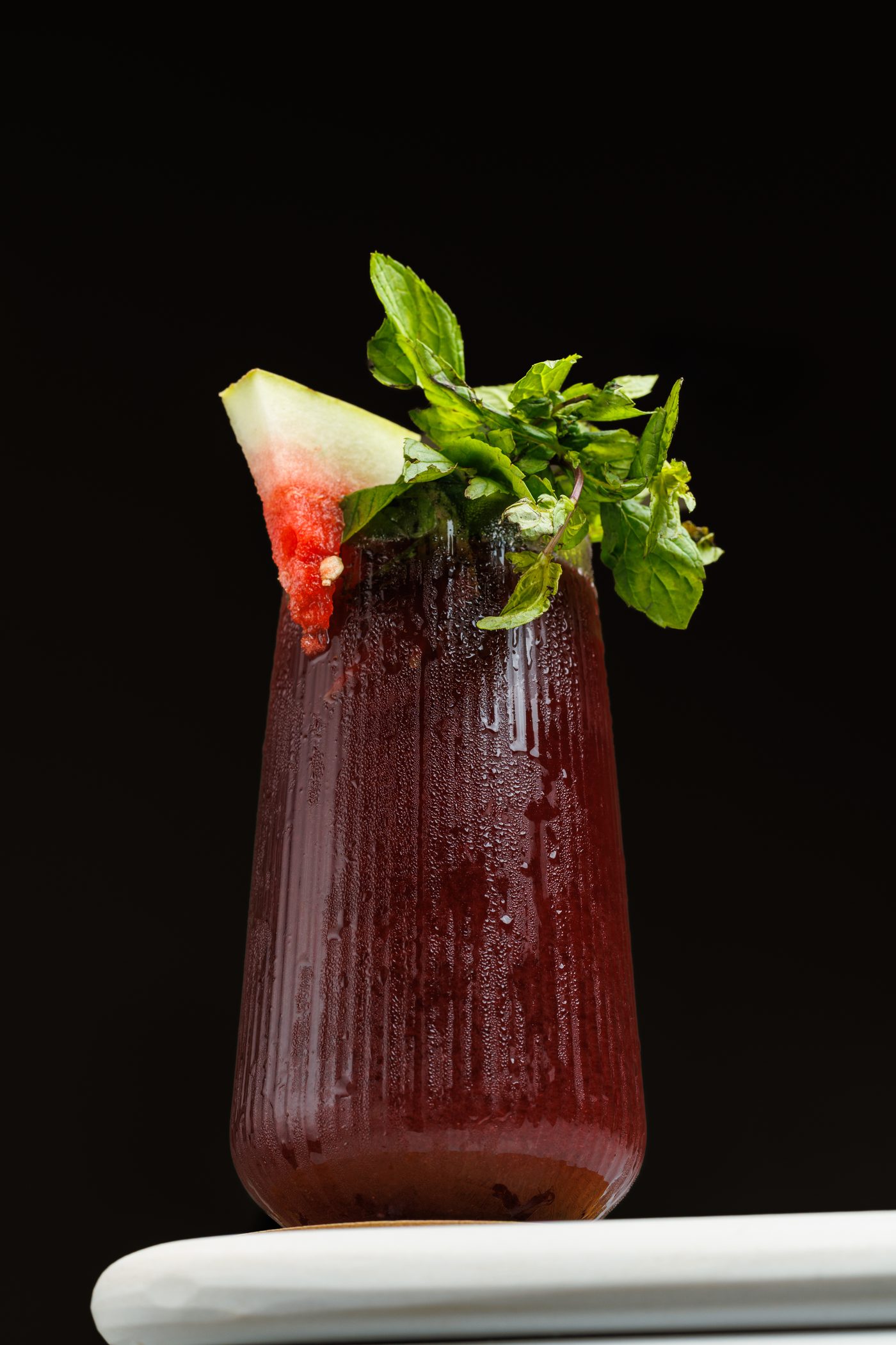 Red Flag cold-press juice served in a ribbed glass with watermelon and fresh mint